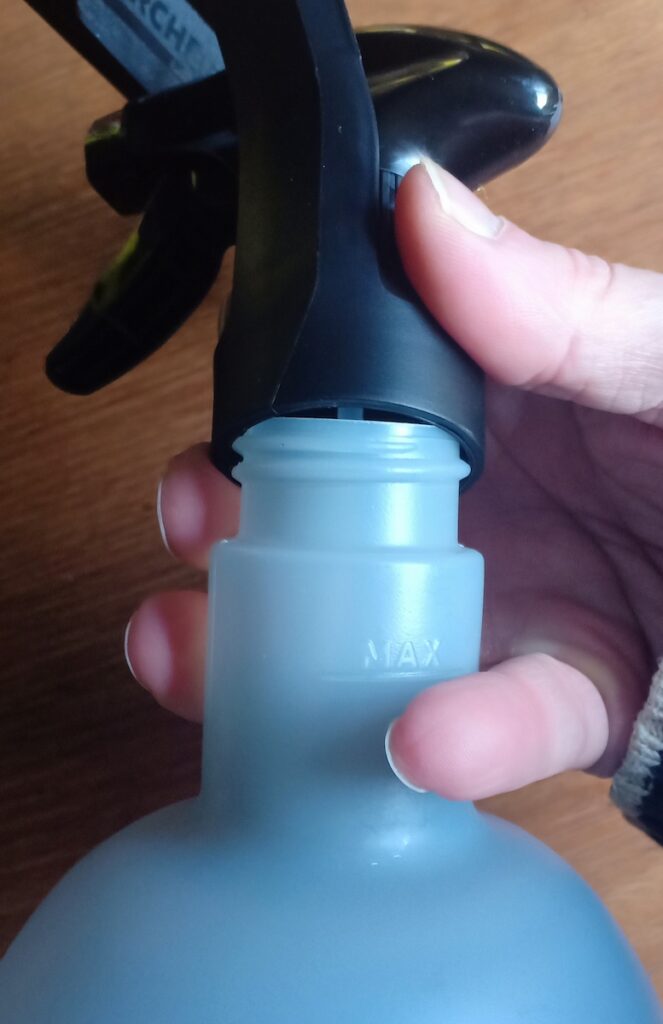 Attaching the bottle to spray top