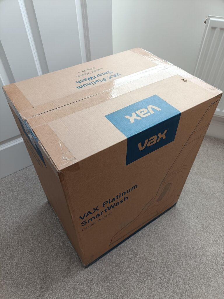 Vax cardboard box sitting on a light grey carpet