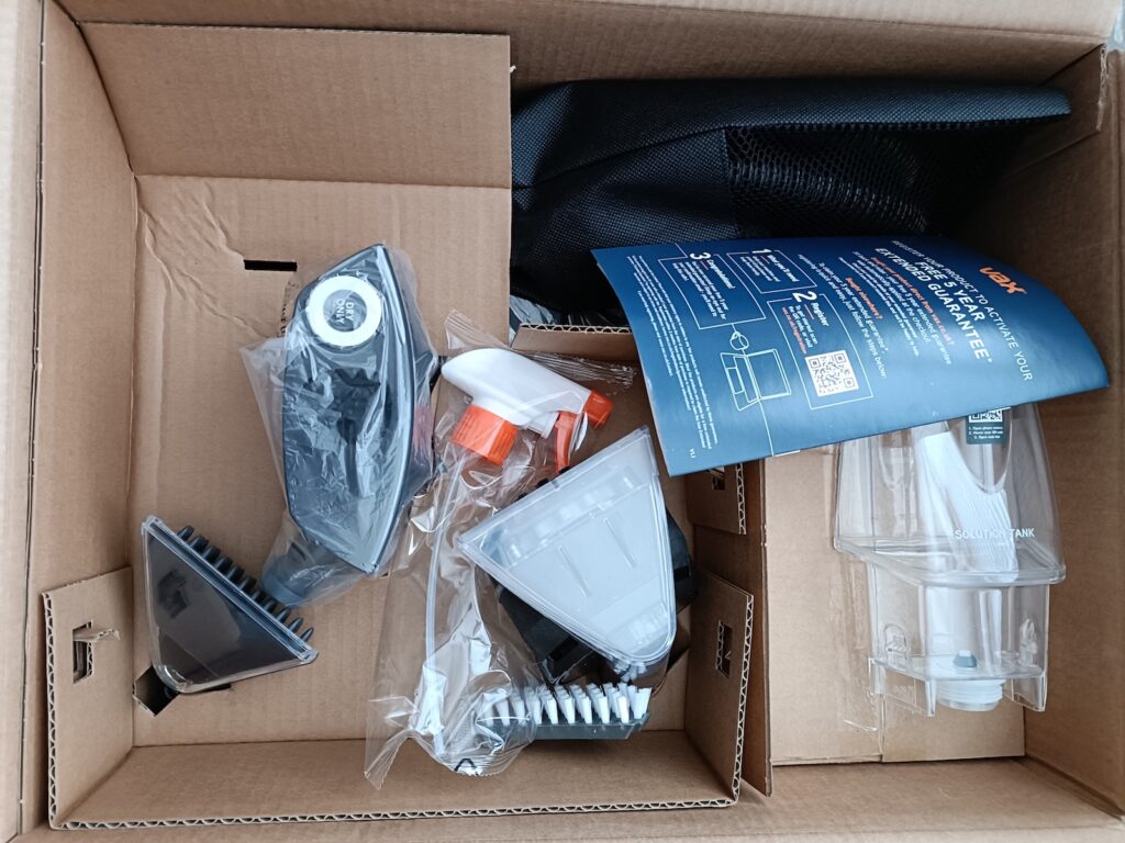 Parts for a Vax Platinum SmartWash packaged tightly in a cardboard box
