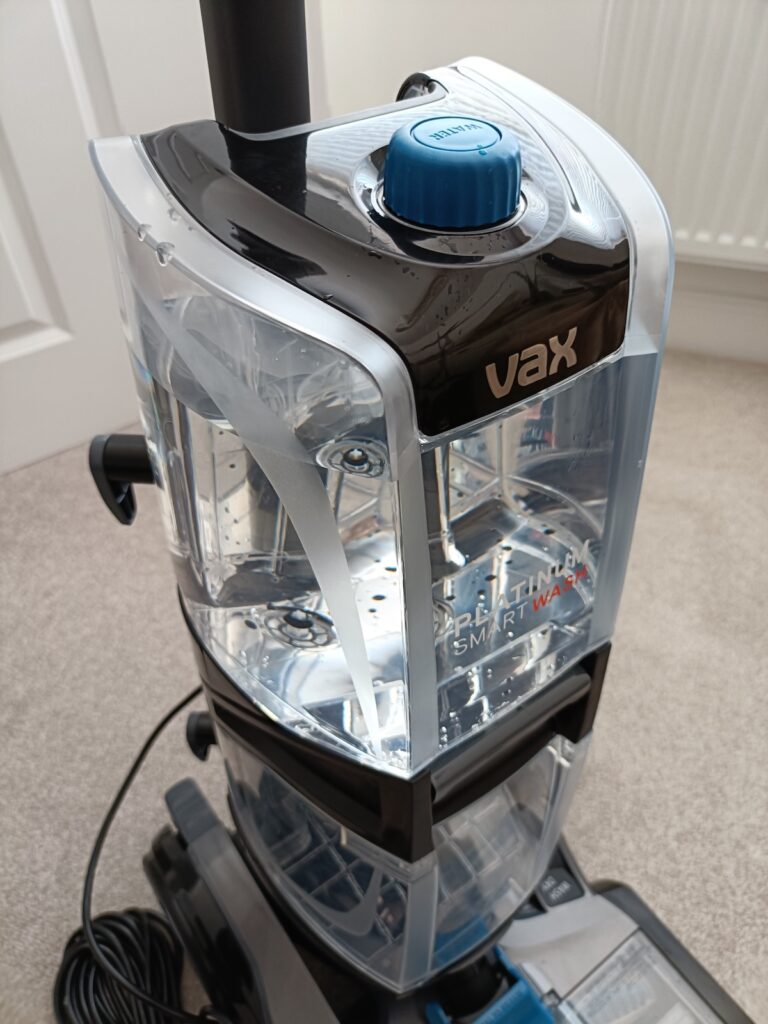 Filled water reservoir sitting on top of the carpet cleaner