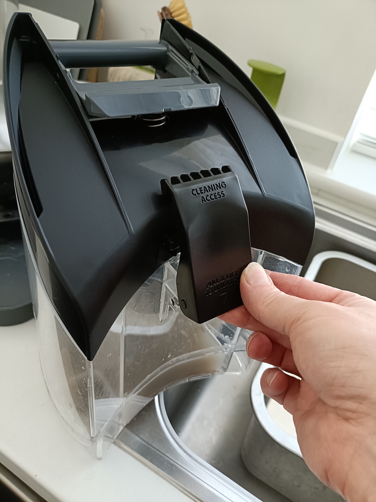 Unclipping the lid of the dirty water container