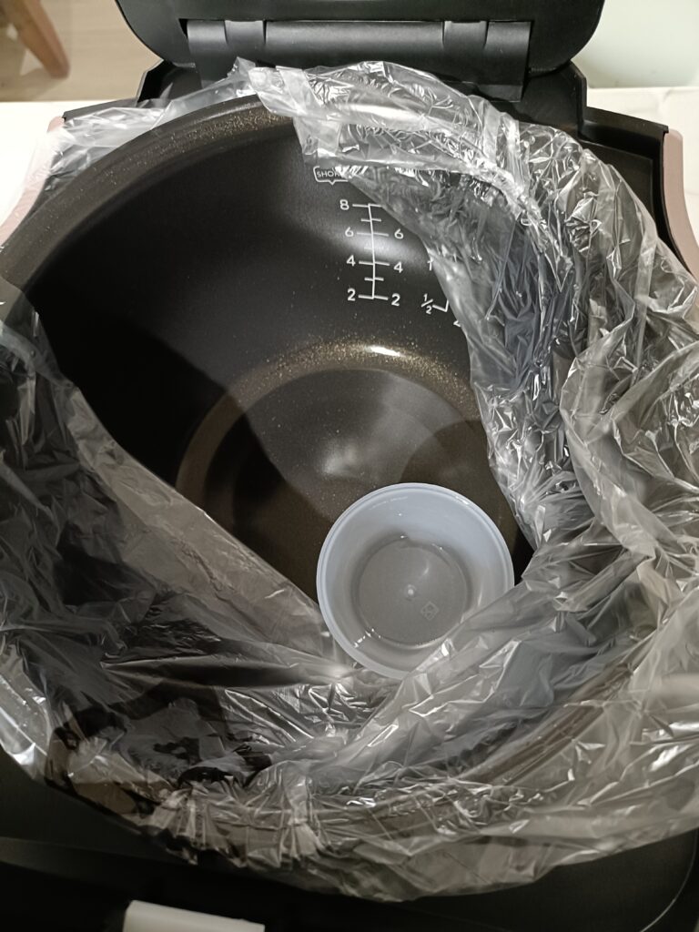 Rice measuring cup stored inside the ceramic bowl.